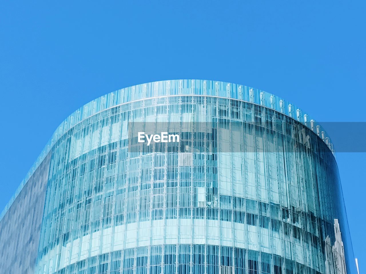 Low angle view of skyscraper against clear blue sky