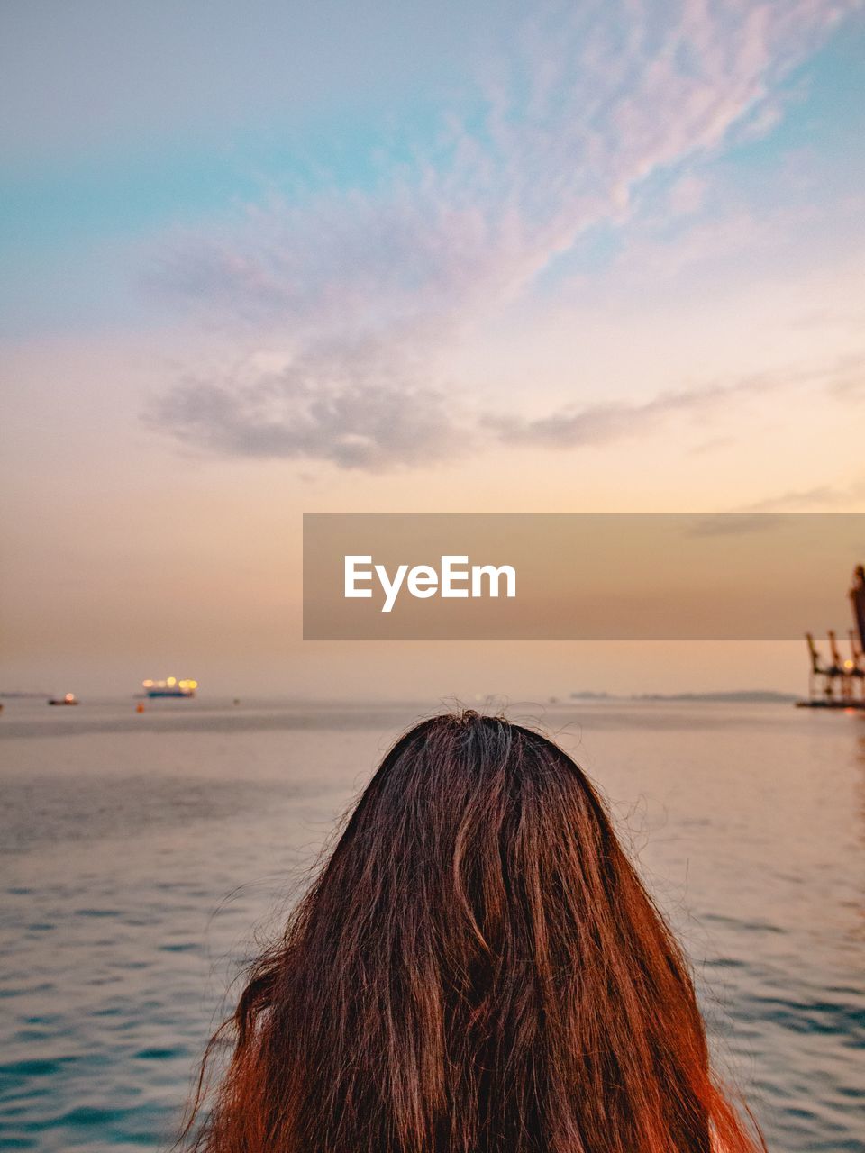 Close-up of woman at sea at sunset