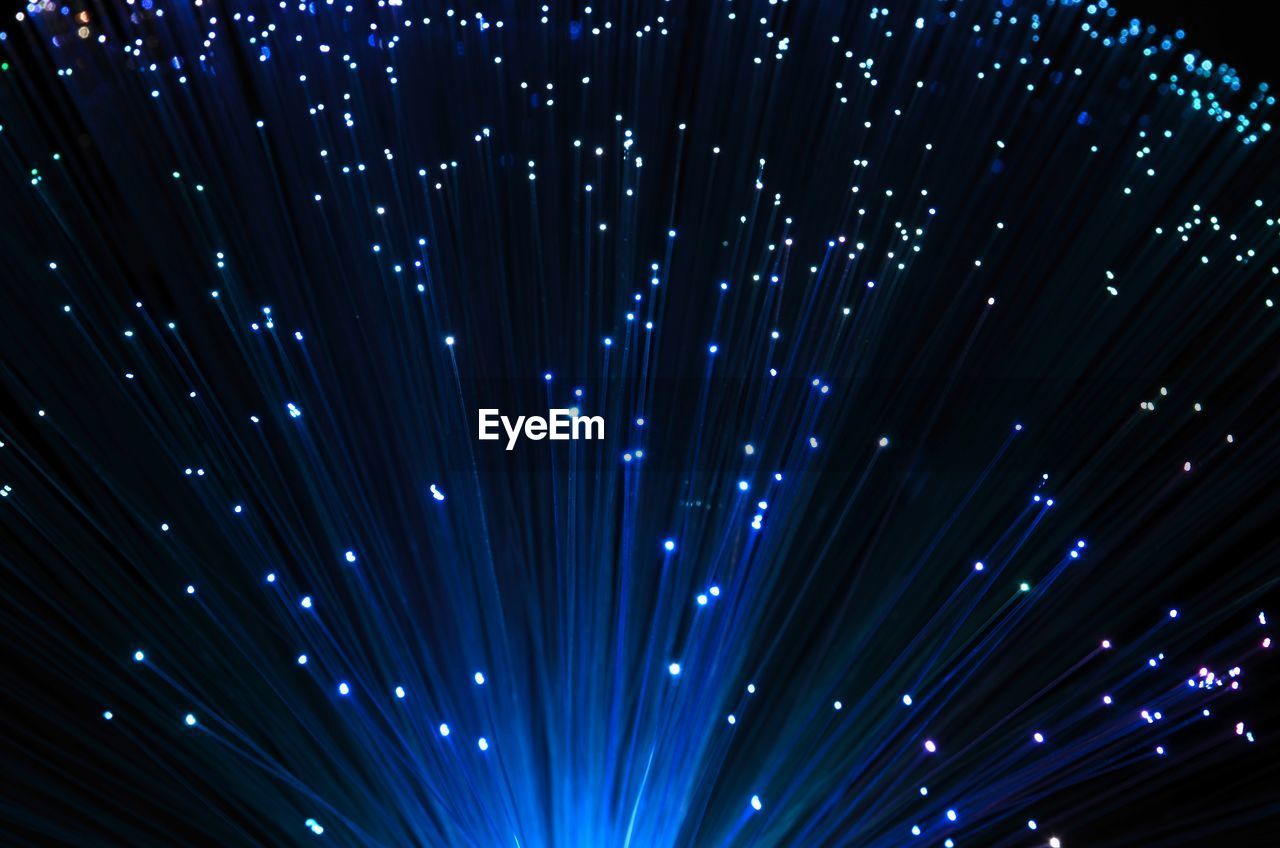 Close-up of illuminated fiber optic against black background