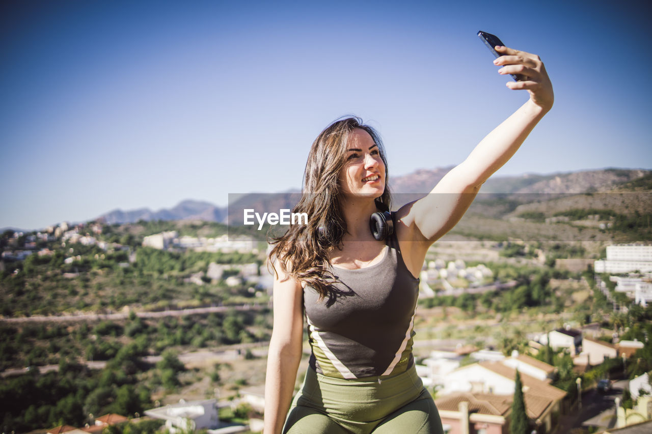 Girl taking a selfie with wireless headphones