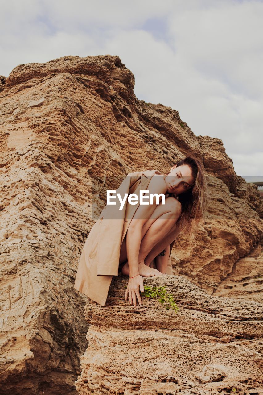 SIDE VIEW OF WOMAN STANDING ON ROCK