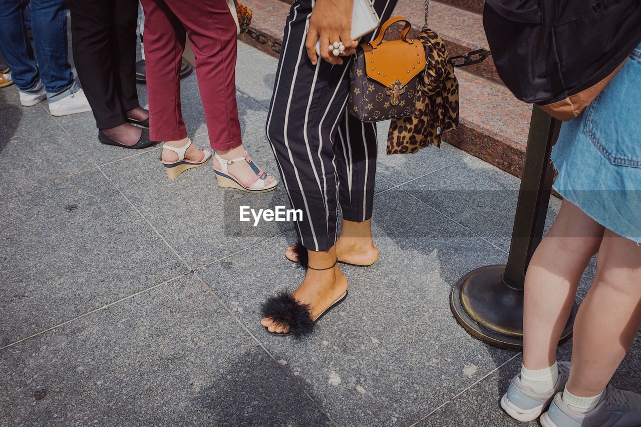 Low section of people standing on footpath