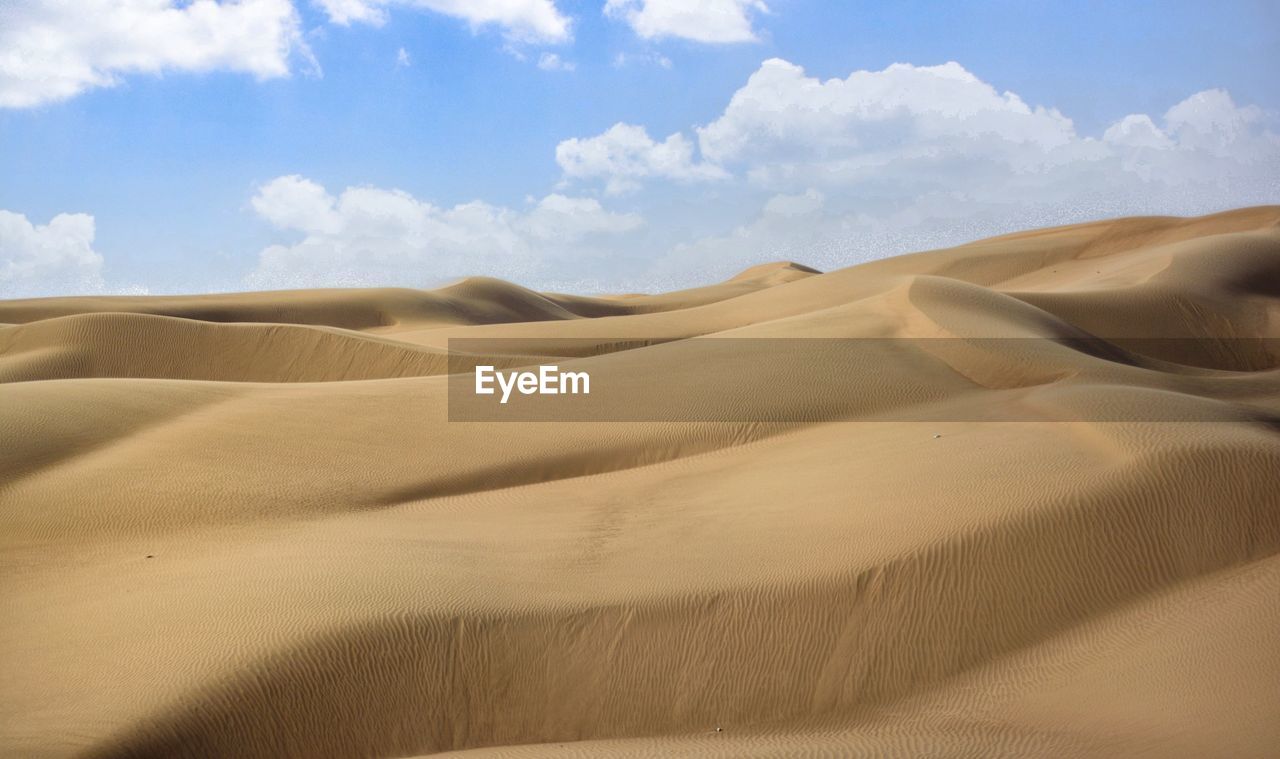 Sand dunes in desert against sky