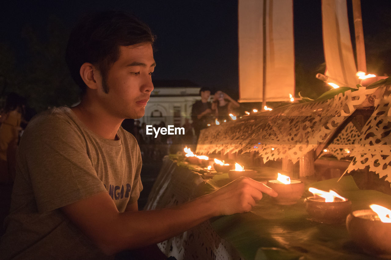 Man holding lit diya during diwali celebration