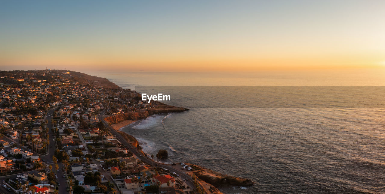 Sunset cliffs, san diego and ocean beach in distance. aerial view of cliffs and road along coast