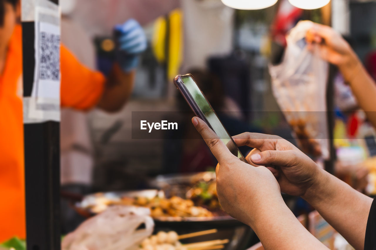 Woman use smartphone scan qr code in food store.