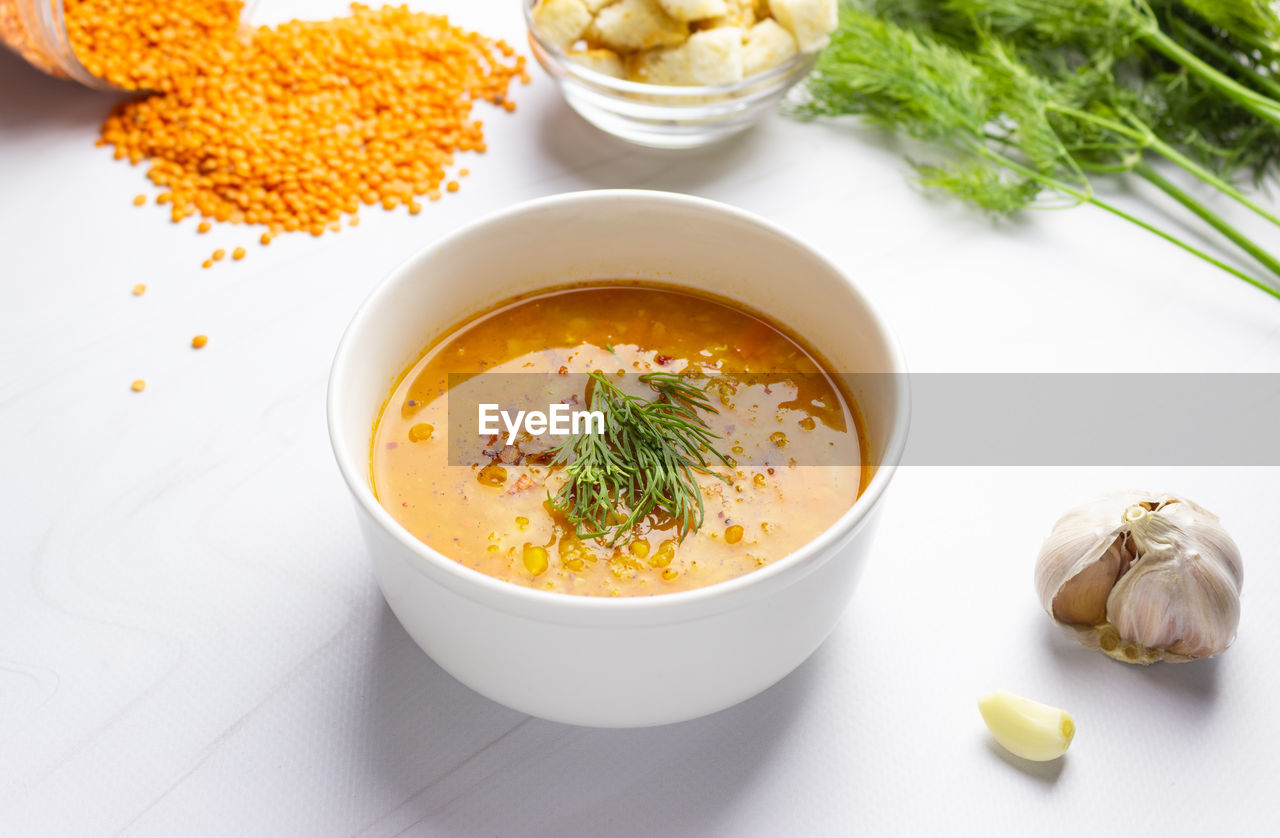 Red lentil soup with ingredients on a light background. traditional turkish or arabic spicy lentil