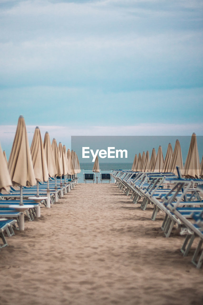 Lounge chairs and closed sunshades on beach