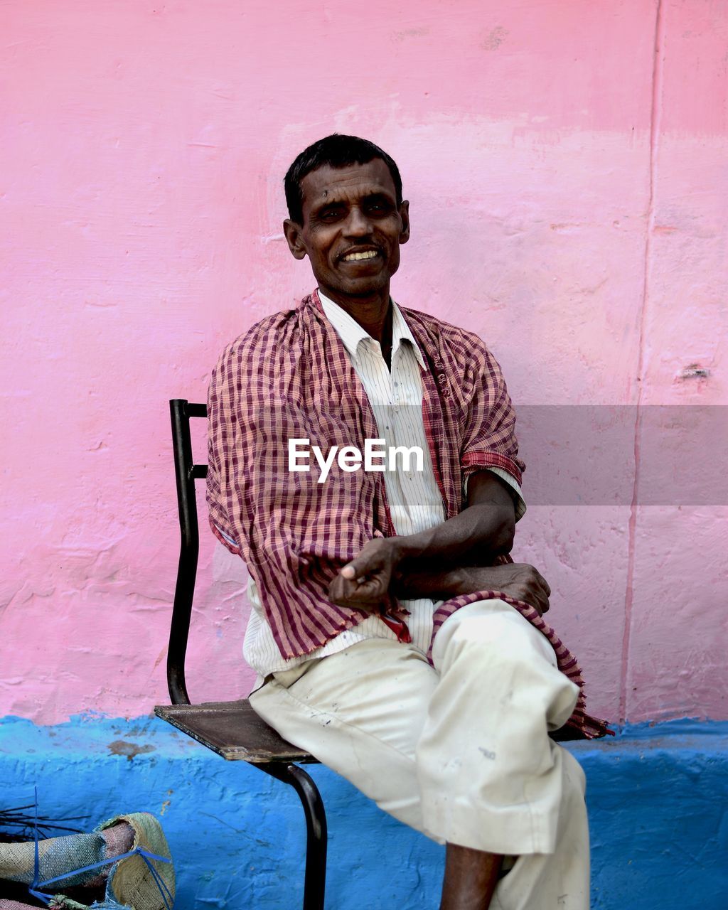 PORTRAIT OF MAN SITTING ON WALL OUTDOORS