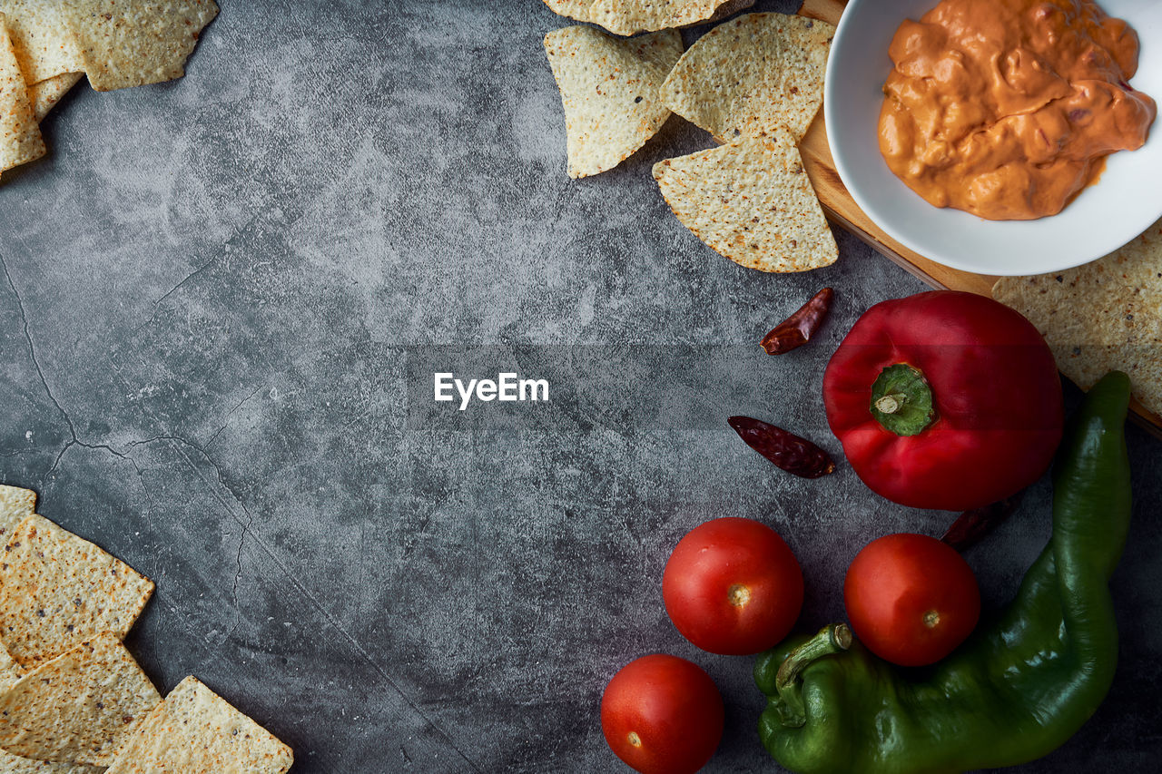 Kitchen background frame with copy space with tomato, pepper, spicy, mexican cheese sauce and nachos