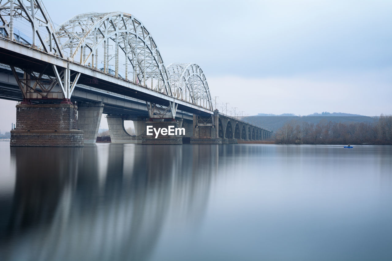 New darnytskyi bridge over river against sky