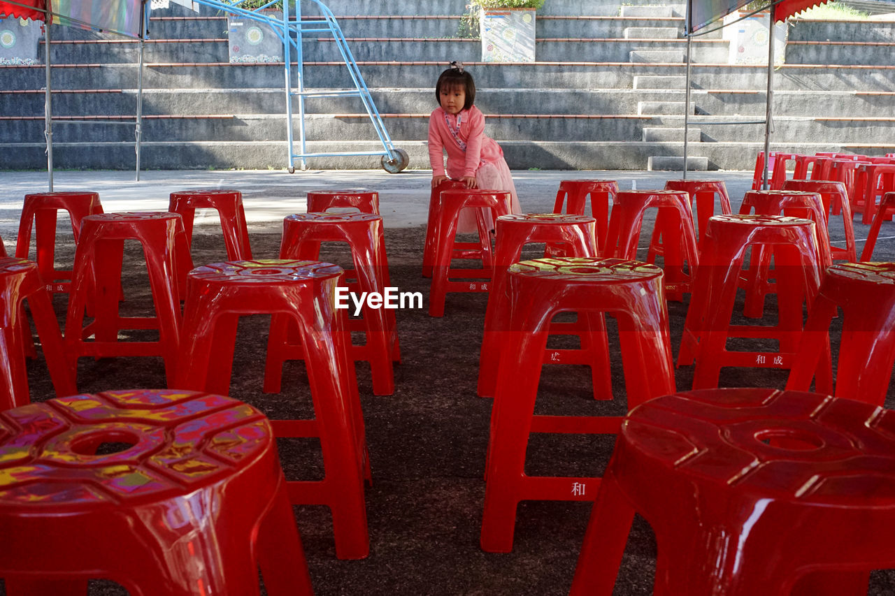 REAR VIEW OF BOY STANDING ON CHAIR