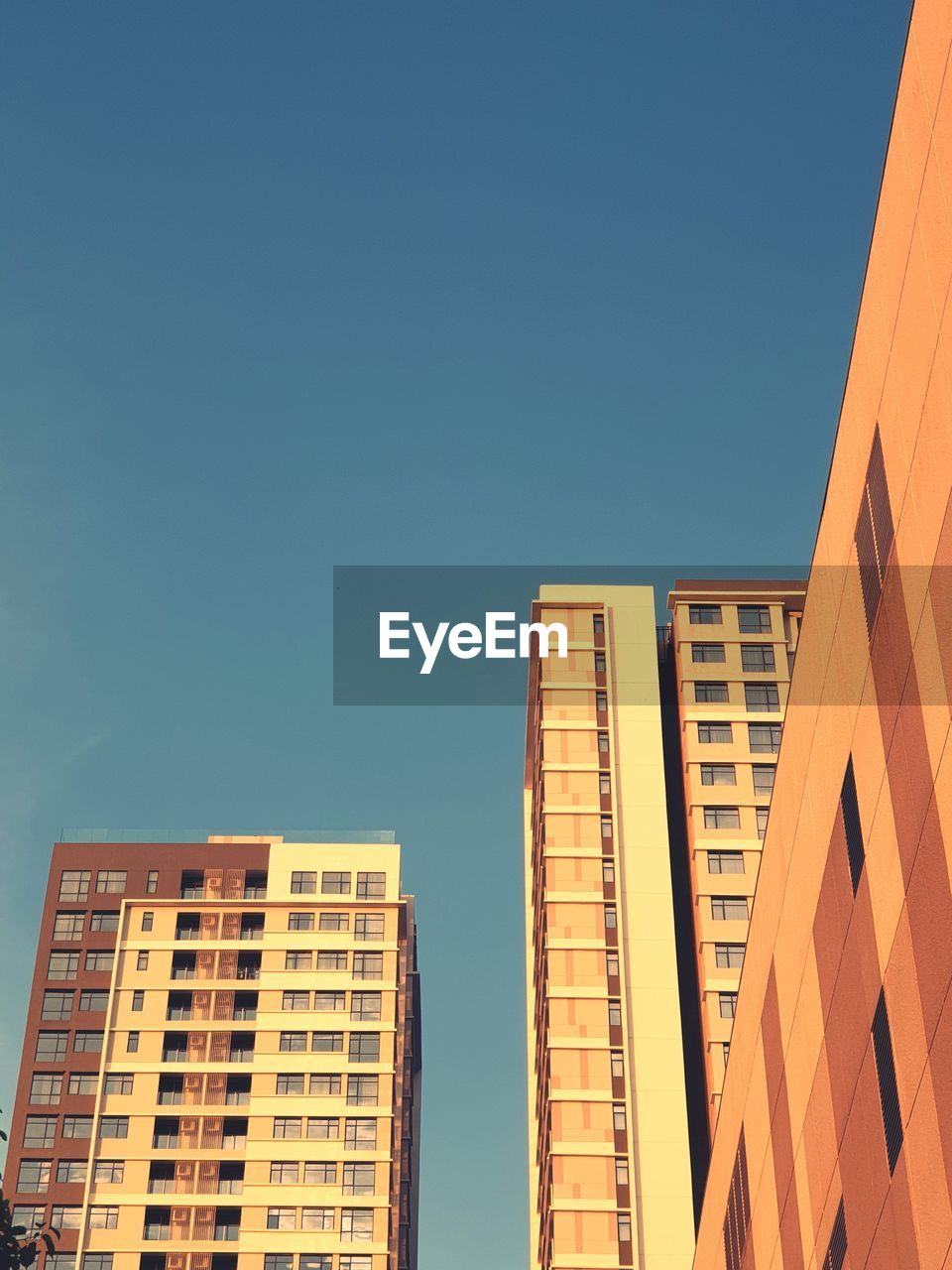 Low angle view of buildings against clear blue sky