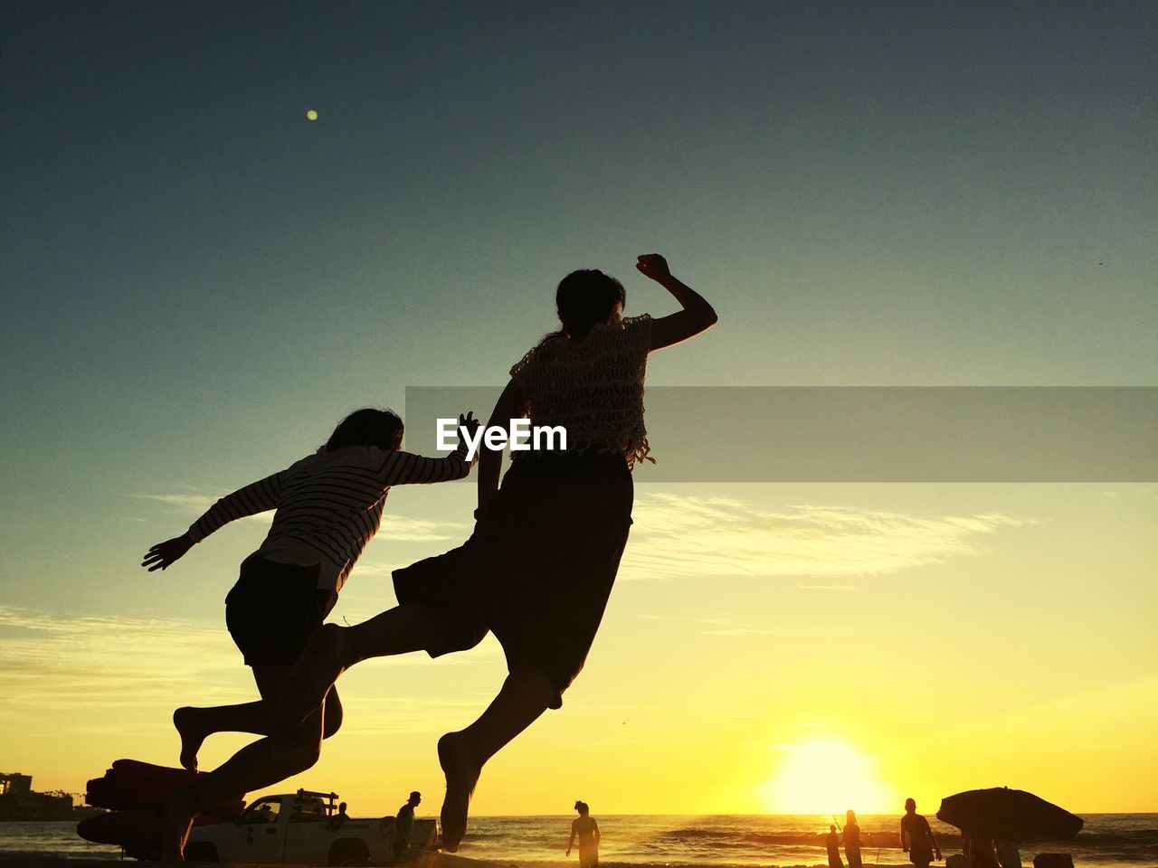 SILHOUETTE MAN JUMPING ON SEA AGAINST SKY