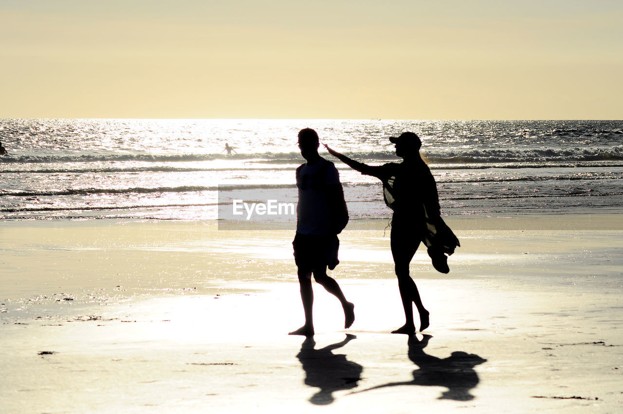 sea, beach, two people, horizon over water, real people, water, nature, sunlight, togetherness, love, scenics, silhouette, sunset, beauty in nature, men, full length, sky, standing, sand, leisure activity, lifestyles, outdoors, bonding, women, friendship, clear sky, day, people