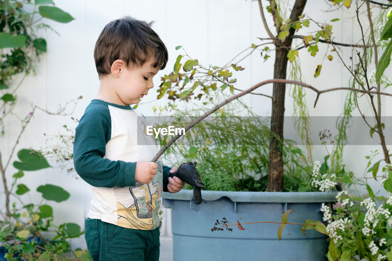 Boy playing with a stick in the garden