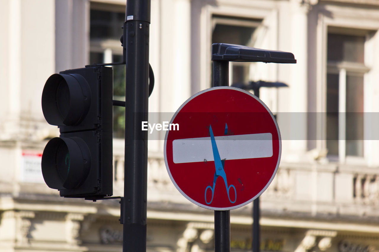 Stop road sign with scissors drawn on it, street art in the center of london