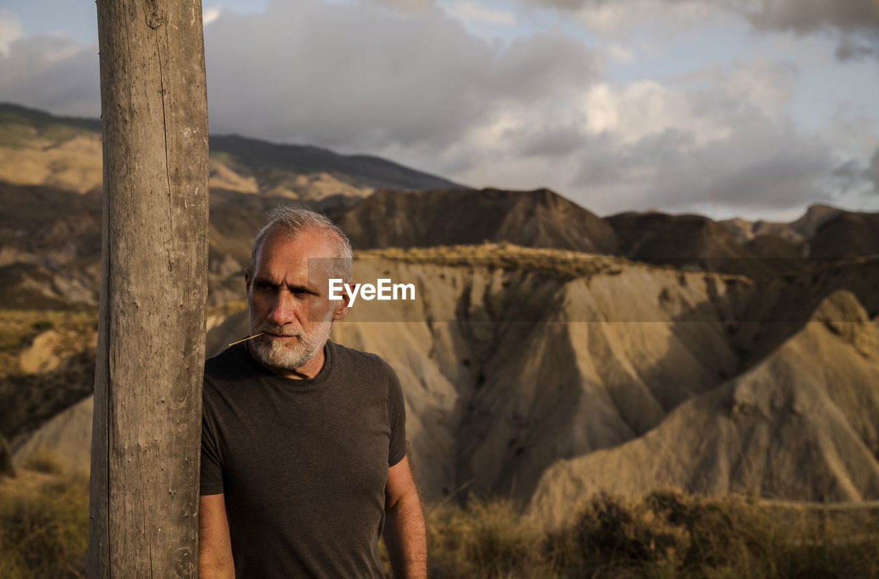 Portrait of man standing on landscape against sky, in tabernas desert, almeria, spain