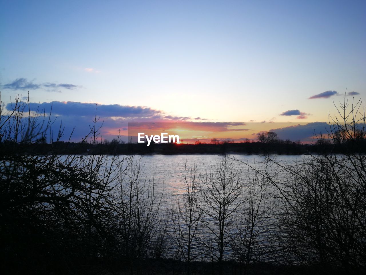 SCENIC VIEW OF LAKE AT SUNSET