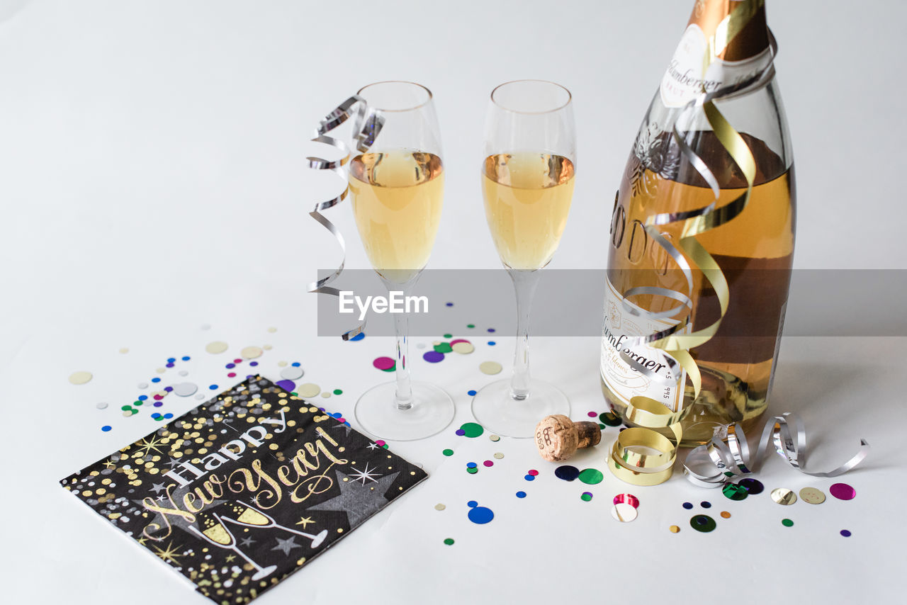 Two glasses and bottle of champagne against white background.