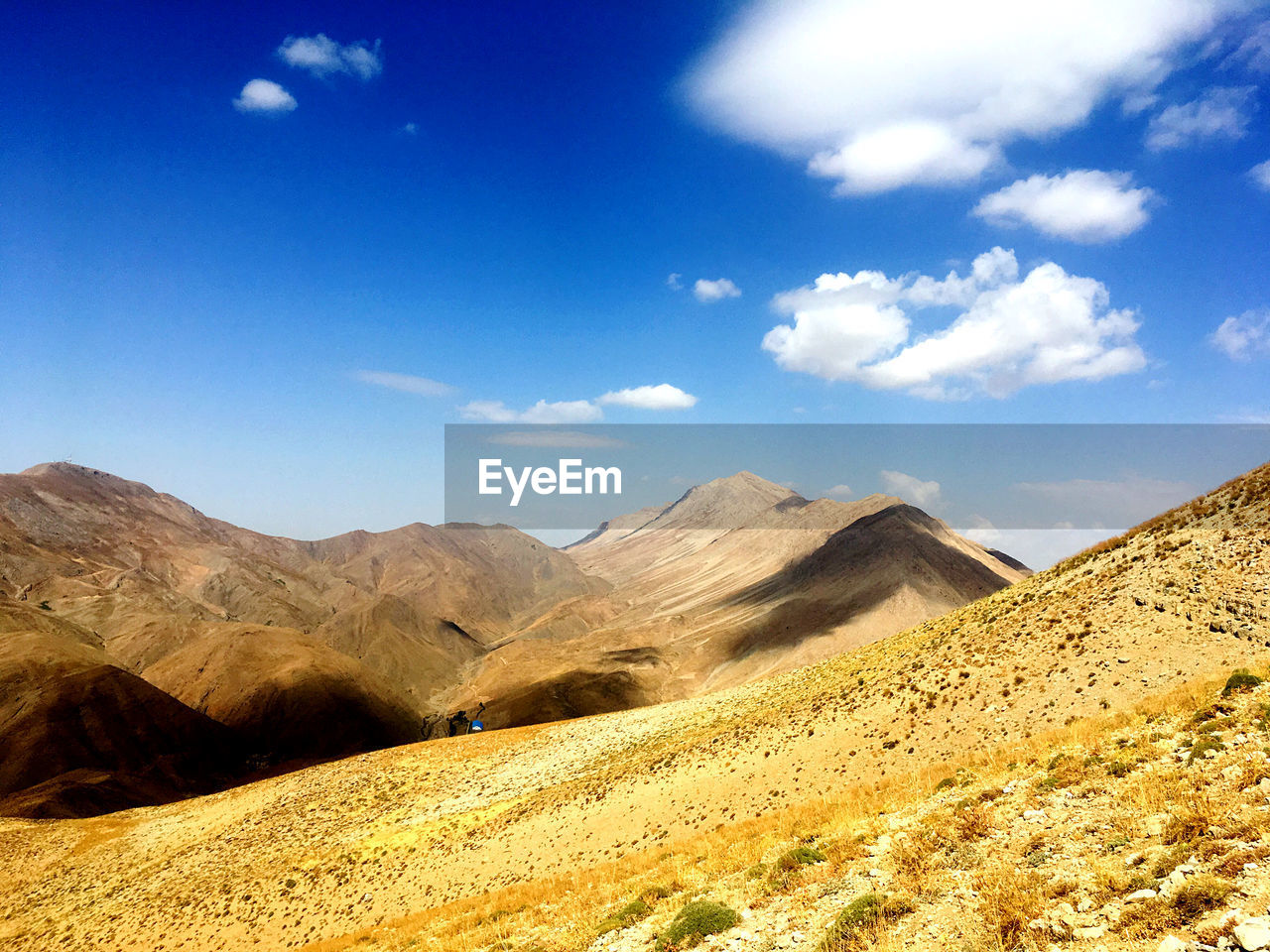 Scenic view of hills against blue sky