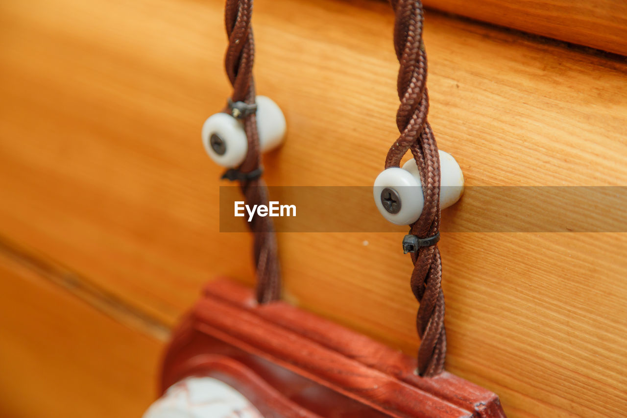 HIGH ANGLE VIEW OF CHAIN HANGING ON WOOD