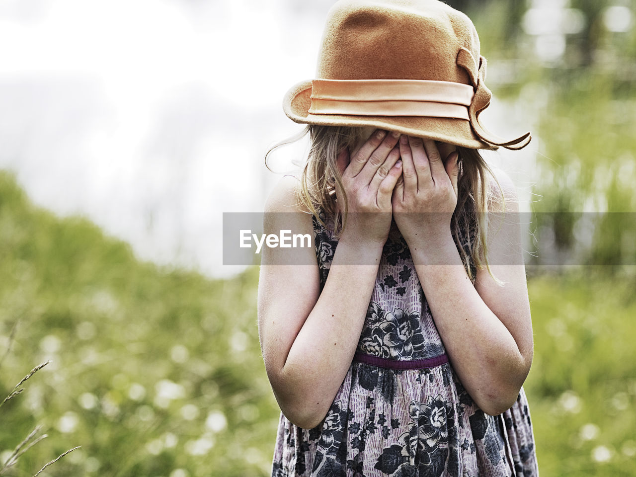 Girl with hands covering face