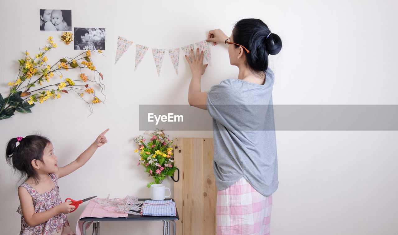 Woman with daughter decorating home