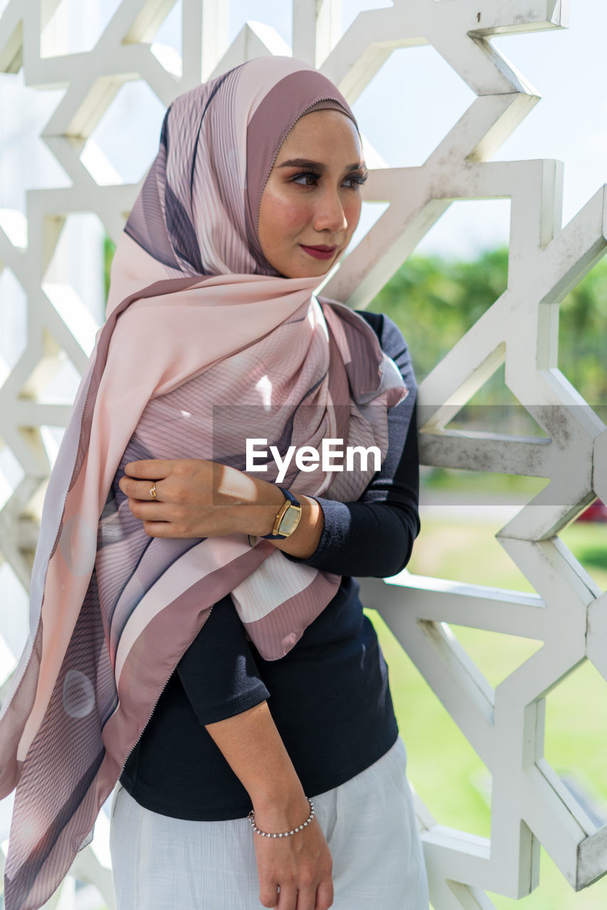 Smiling woman in hijab standing at mosque