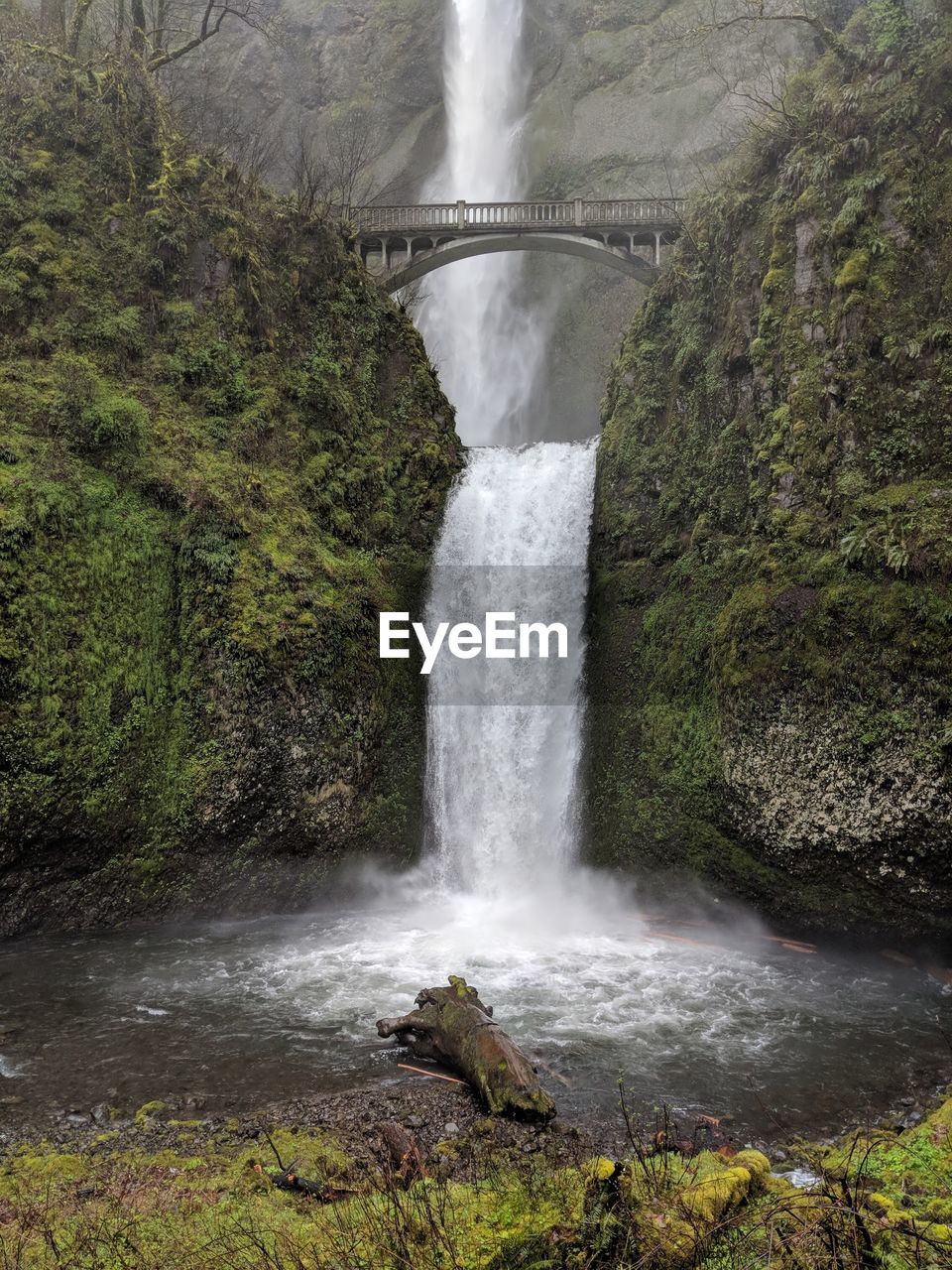 SCENIC VIEW OF WATERFALL ALONG ROCKS