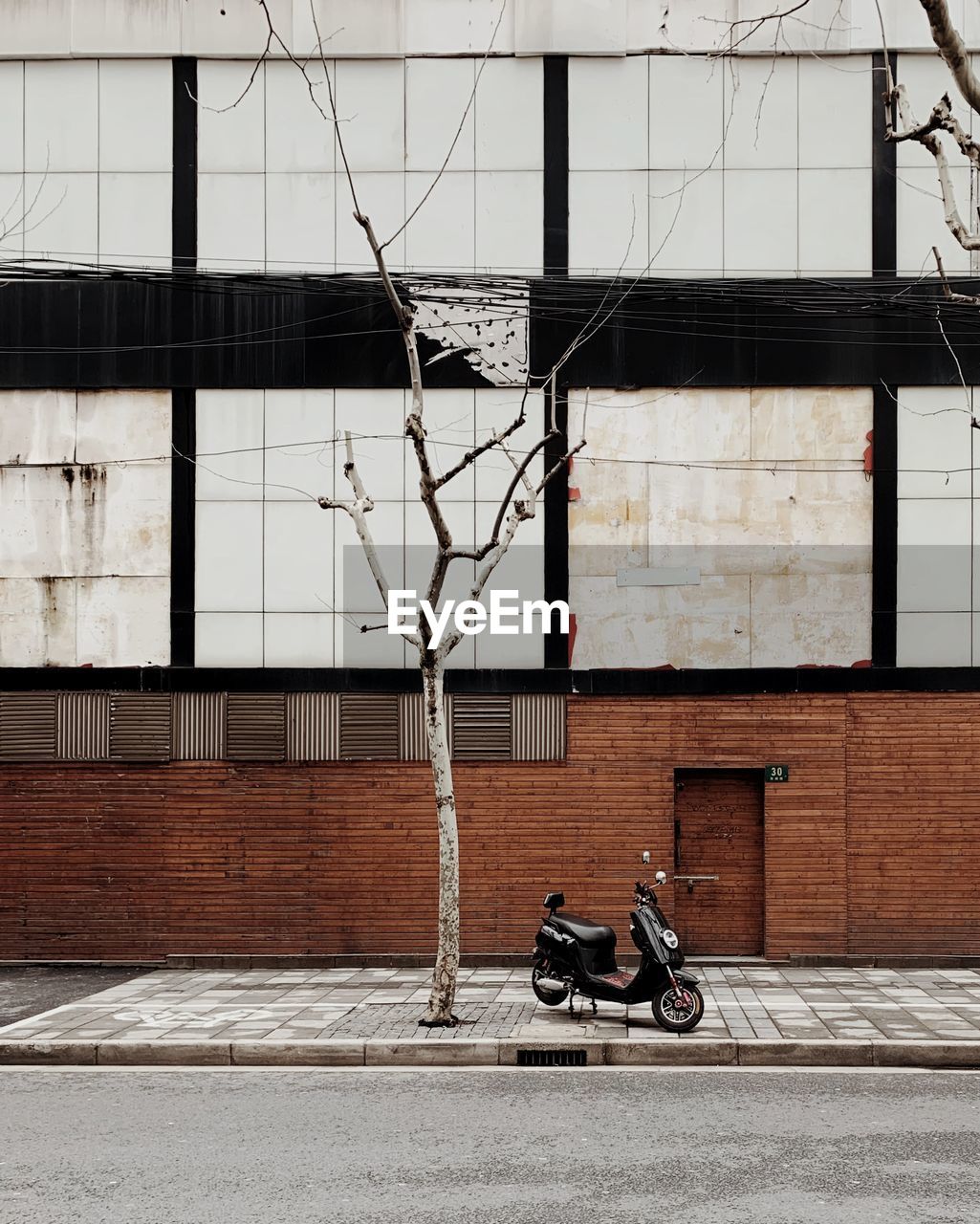 BICYCLE PARKED ON STREET AGAINST BUILDING