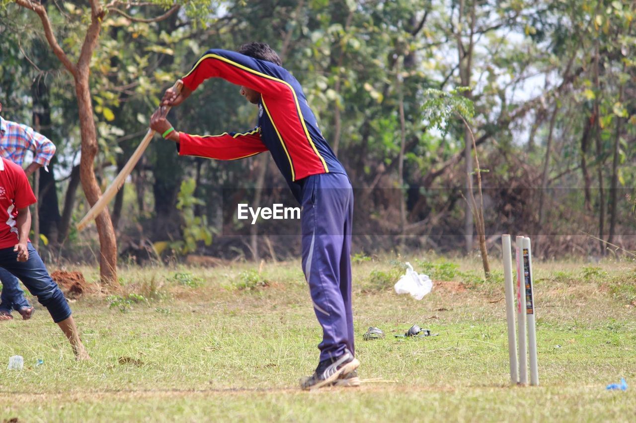 Man playing cricket on field