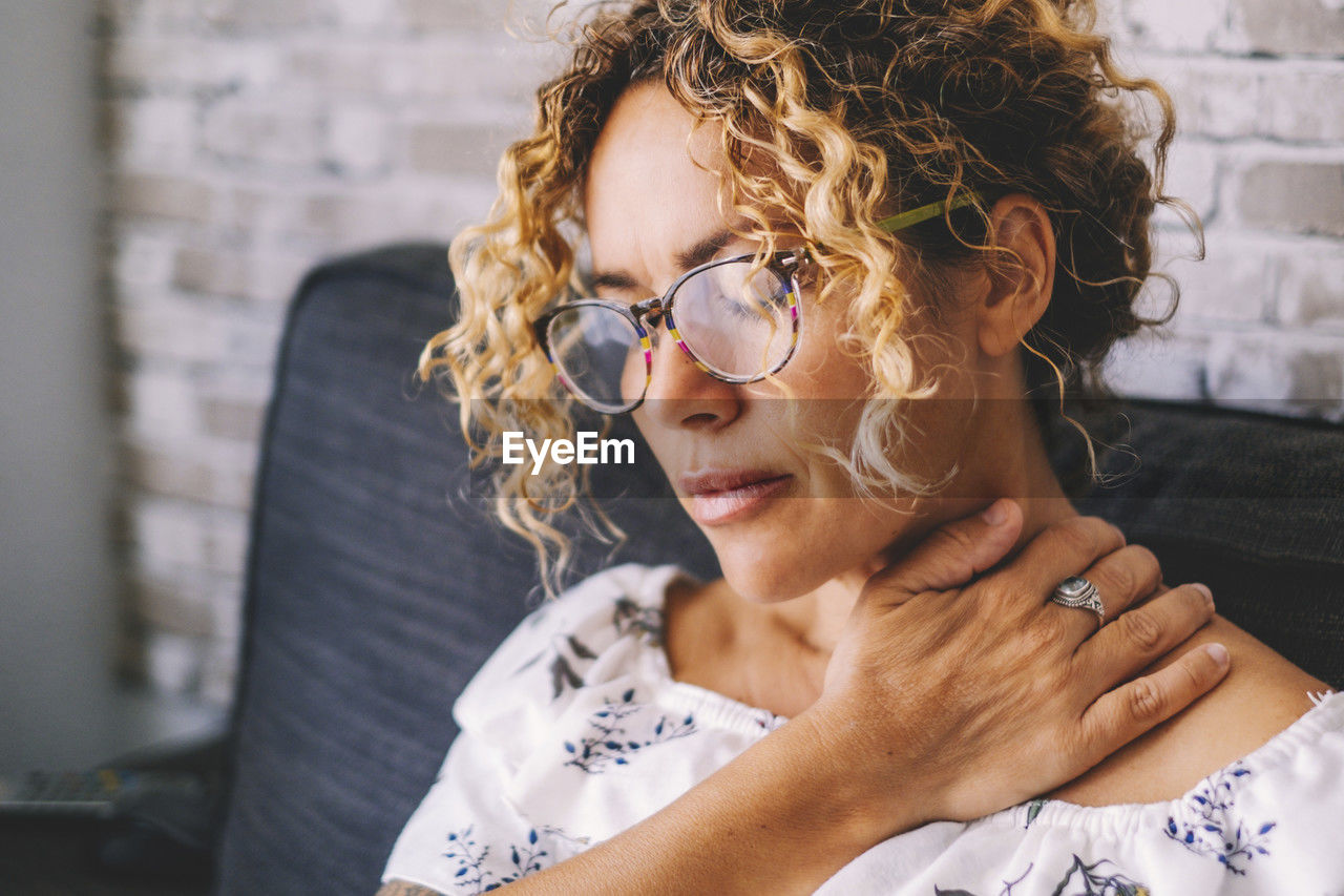 portrait of young woman wearing sunglasses while sitting at home