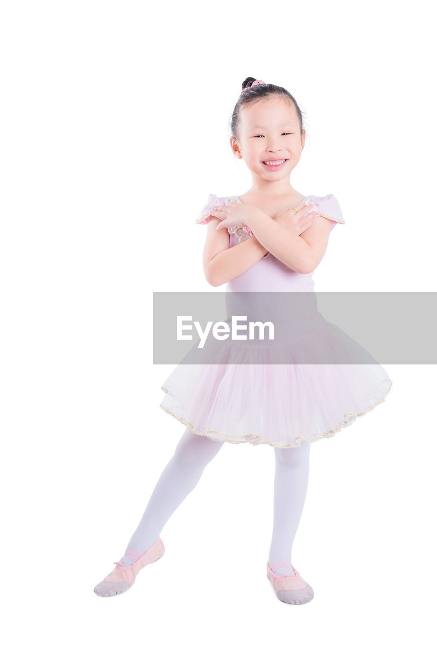 Portrait of smiling girl dancing against white background