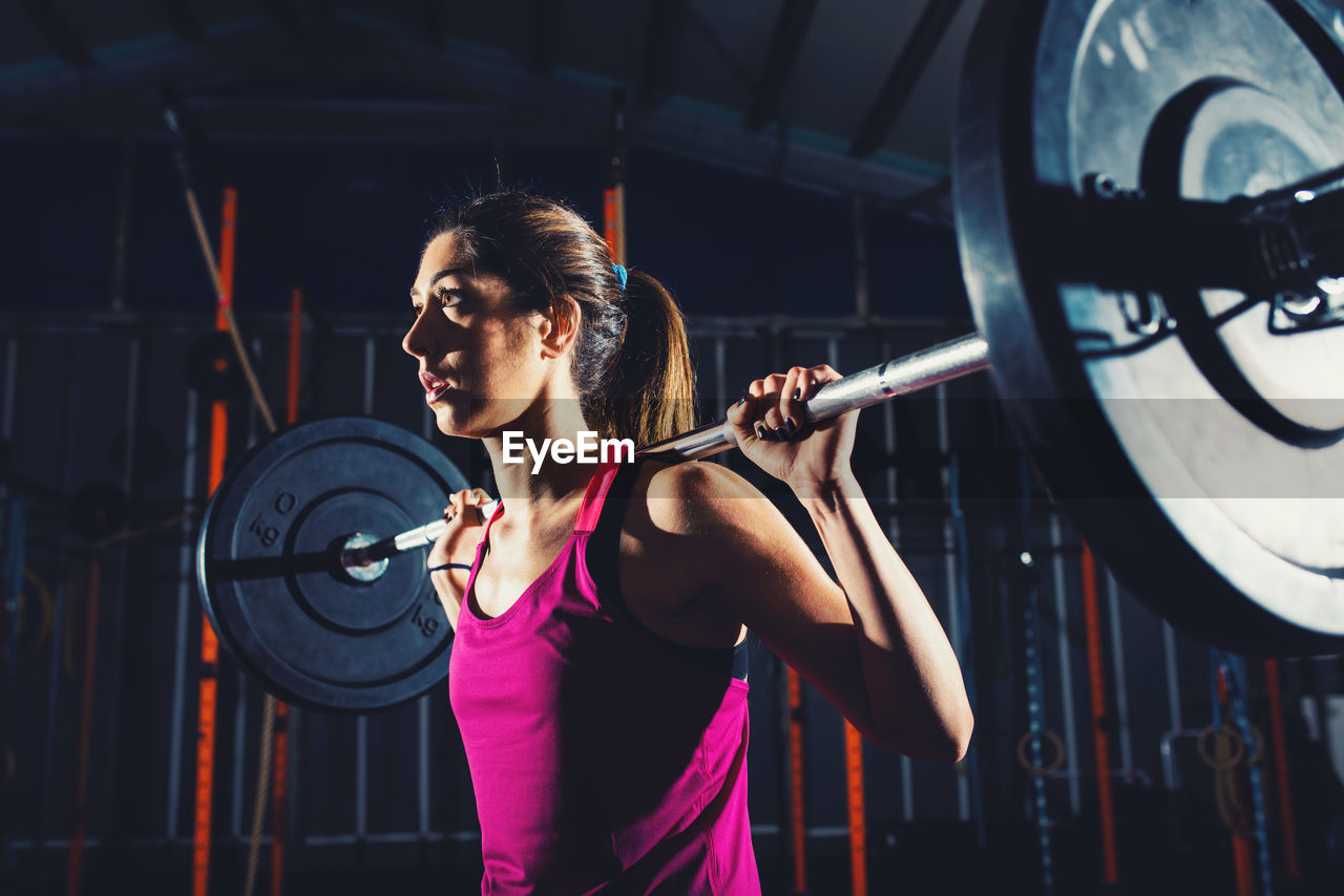 portrait of young man exercising in gym at night