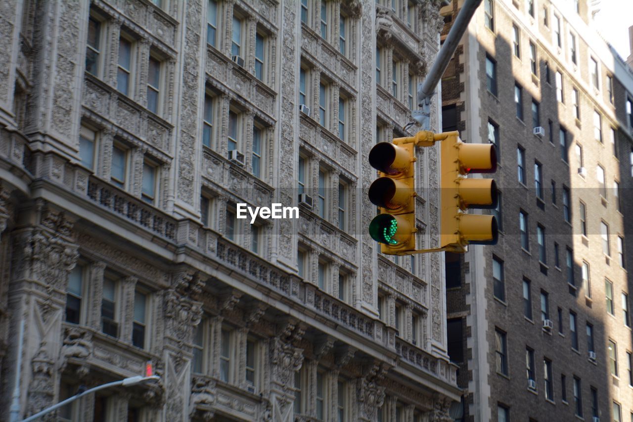 Low angle view of road signal traffic lights against buildings