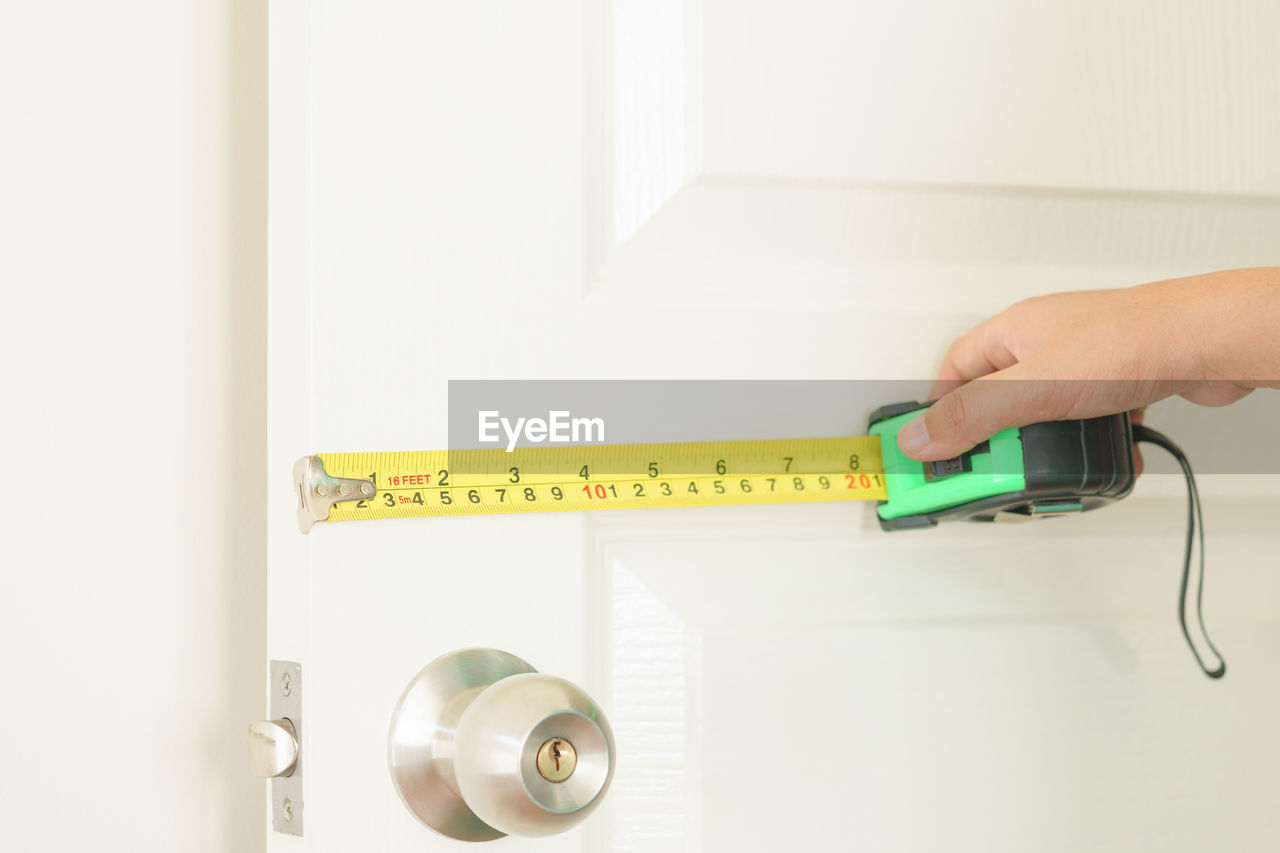 Close-up of hand measuring door