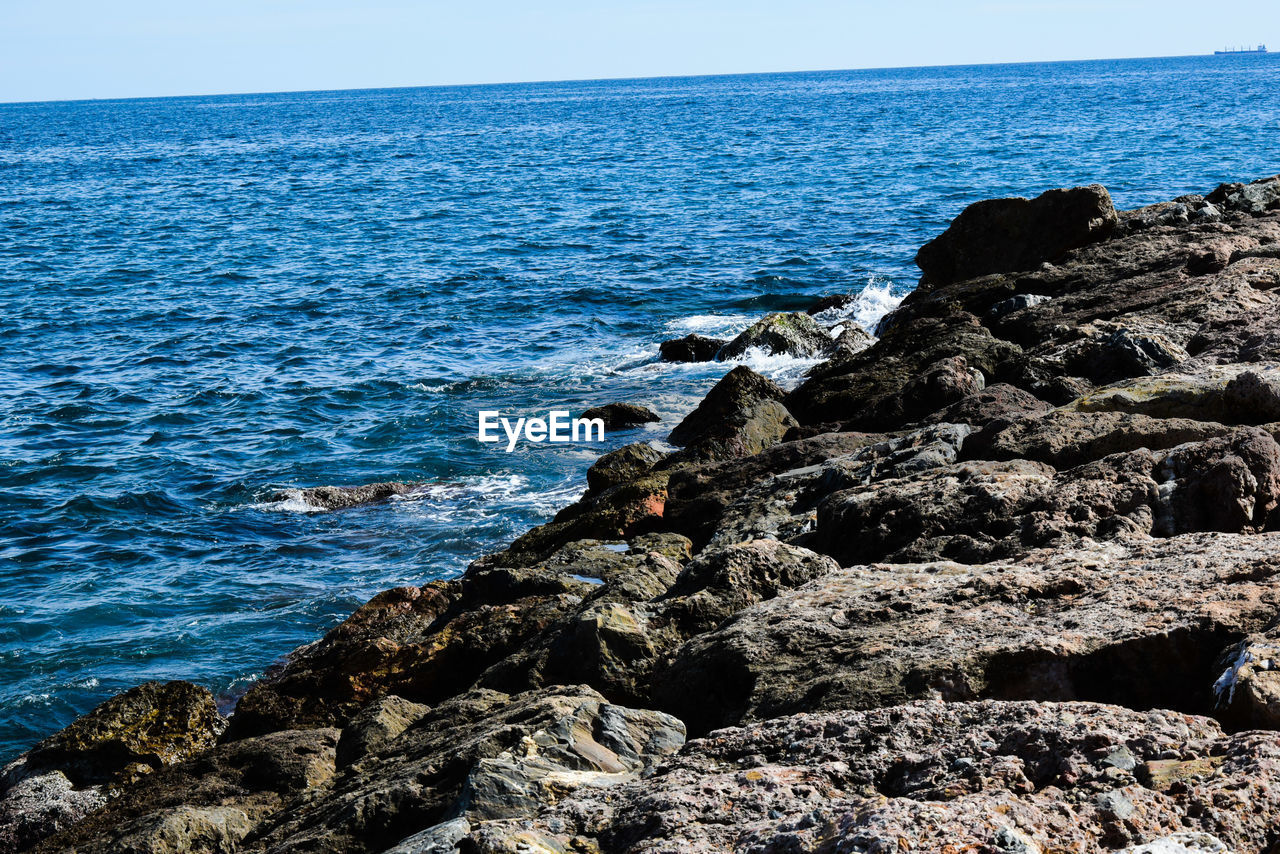 Rock formation on beach against sky