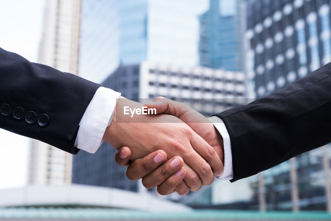 CROPPED IMAGE OF MAN HAND AGAINST WHITE WALL