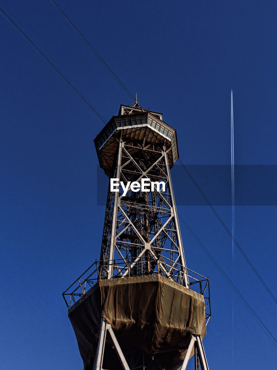 Low angle view of water tower against clear blue sky