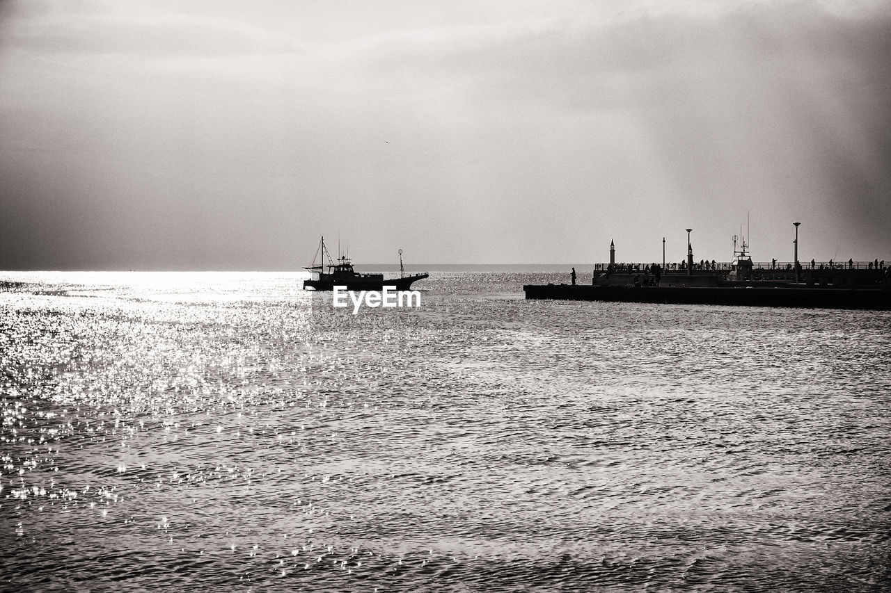 Silhouette of boat in sea against sky