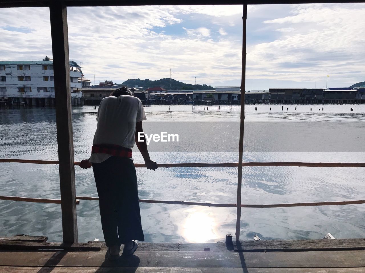 REAR VIEW OF WOMAN STANDING ON RIVERBANK