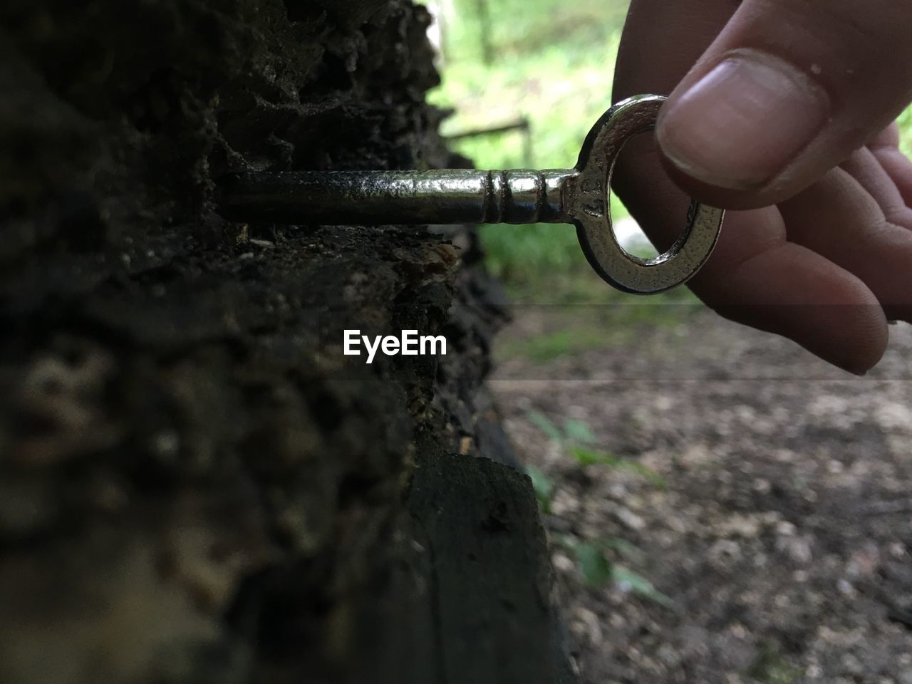 Cropped hand holding key on wood