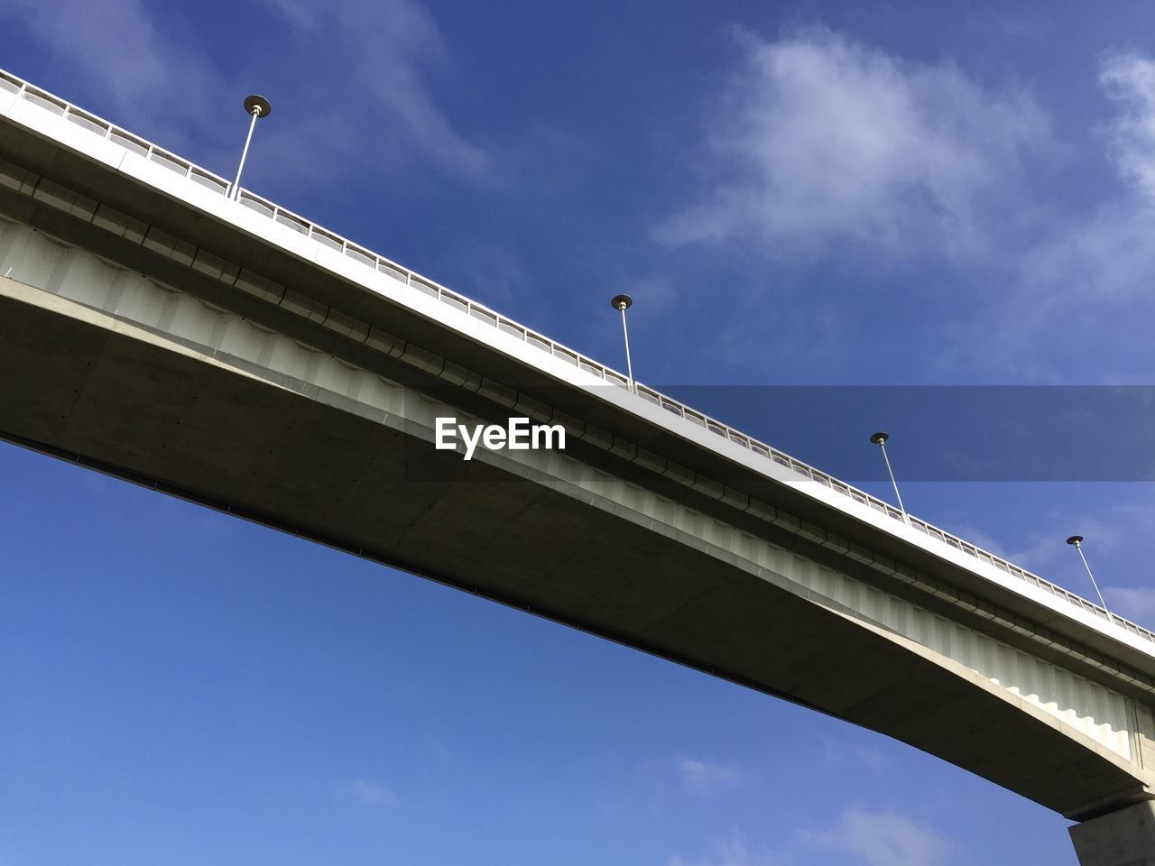 LOW ANGLE VIEW OF ELEVATED ROAD AGAINST CLOUDY SKY