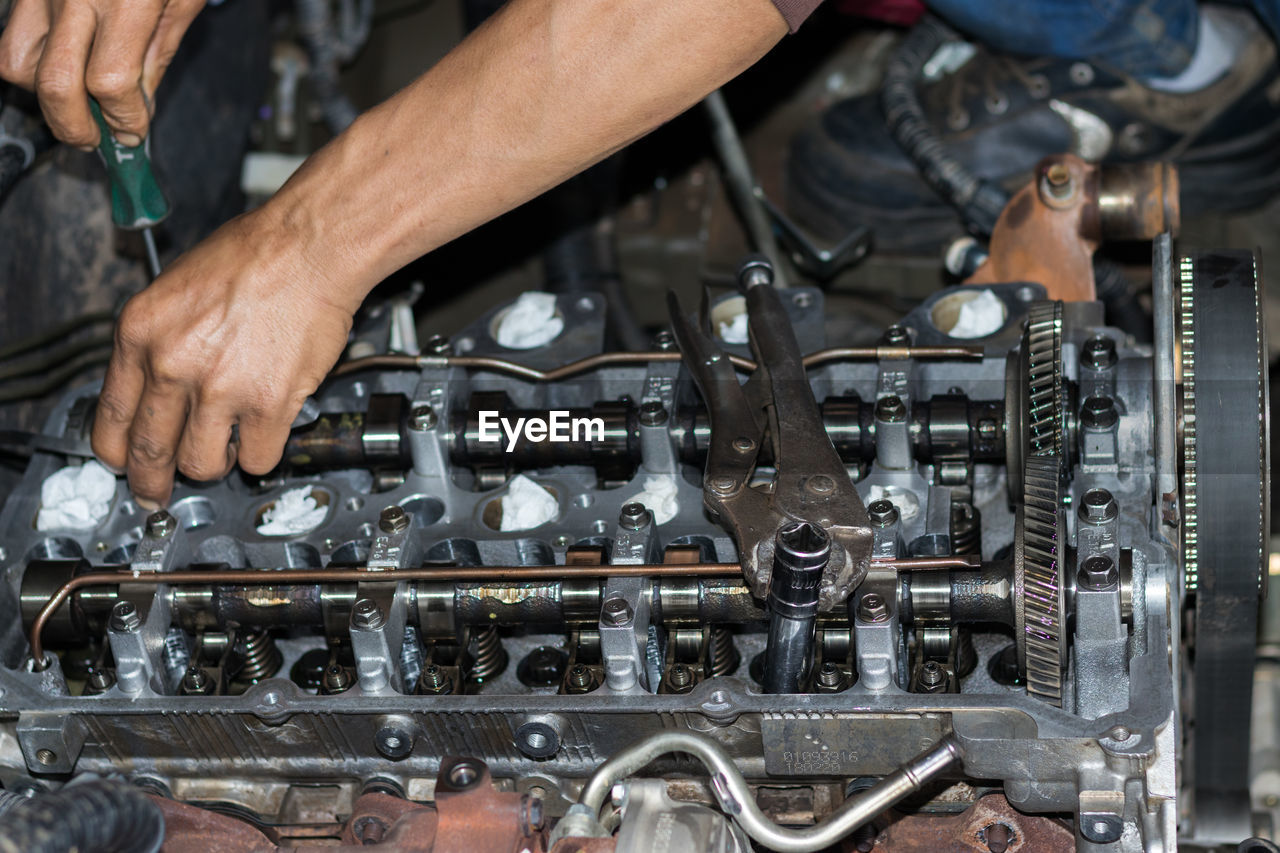 The mechanic is checking the engine.