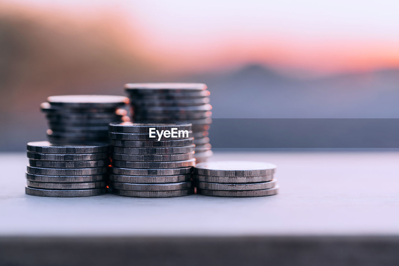 Close-up of growth coin stack on table under sunset background. saving money concept