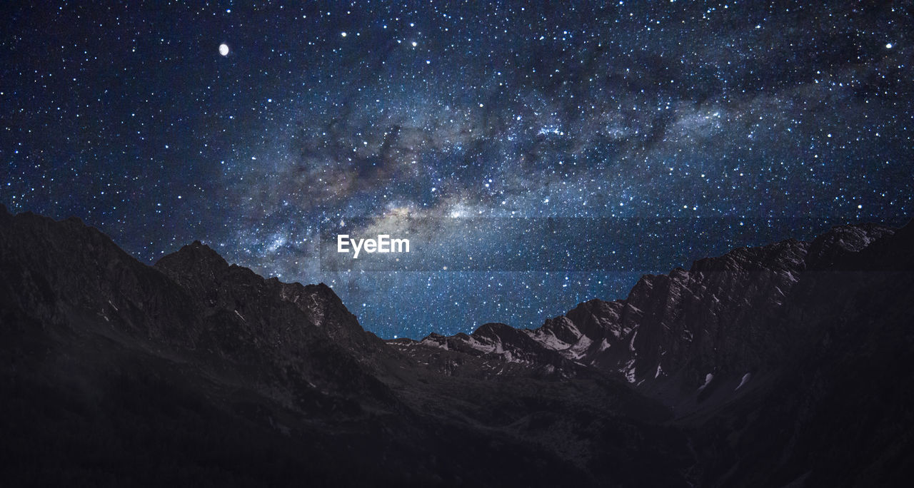 Scenic view of mountains against sky at night