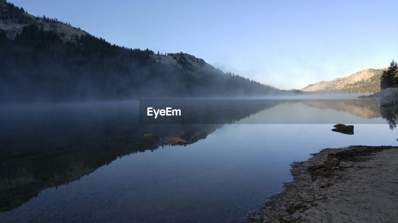 Scenic view of lake by mountains against sky