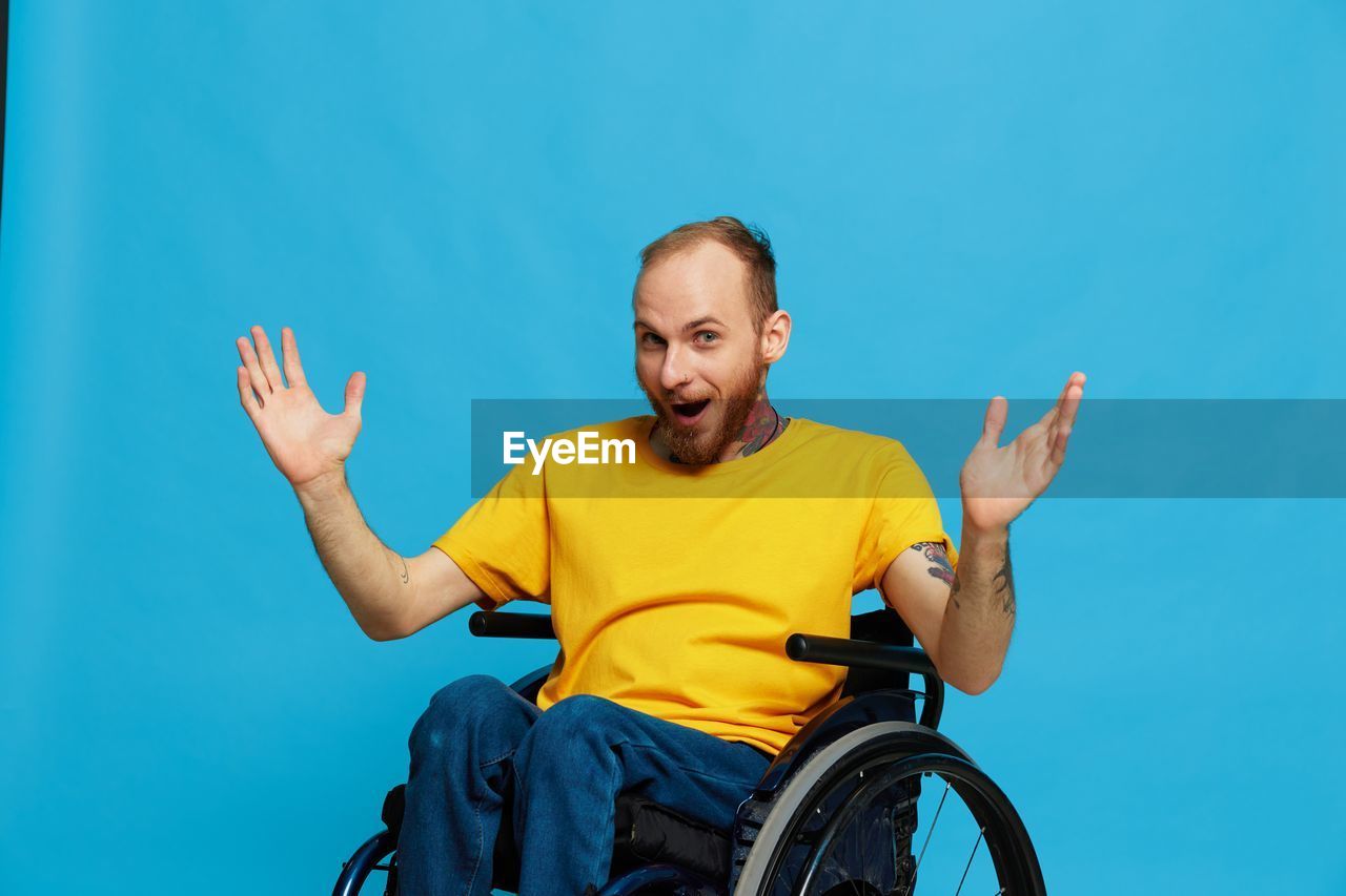 portrait of boy playing with bicycle against clear blue background