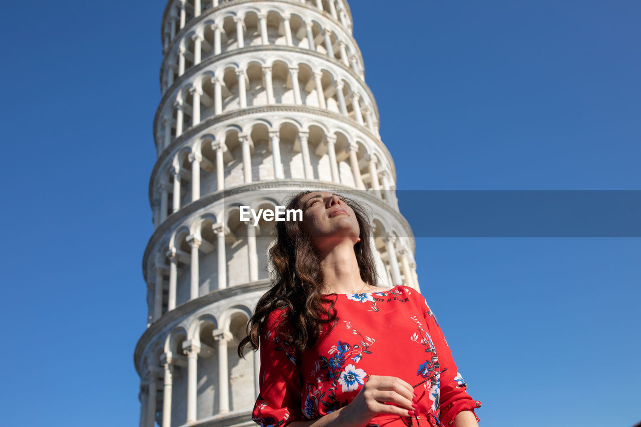 Woman standing against leaning tower of pisa in italy